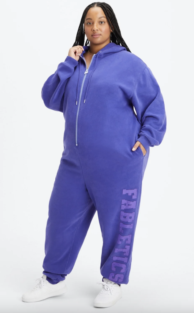 purple zip-up onesie with hood and pockets with Fabletics written down the left leg